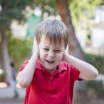 child with is hand on his ears