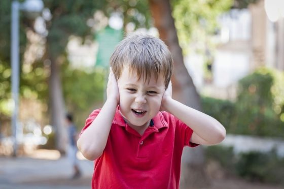 child with is hand on his ears